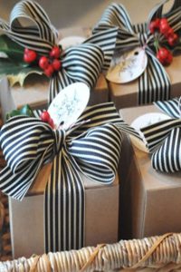 gifts with black and white striped ribbon and red berries