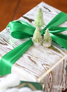 Christmas gift wrap with bright green ribbon and miniature trees