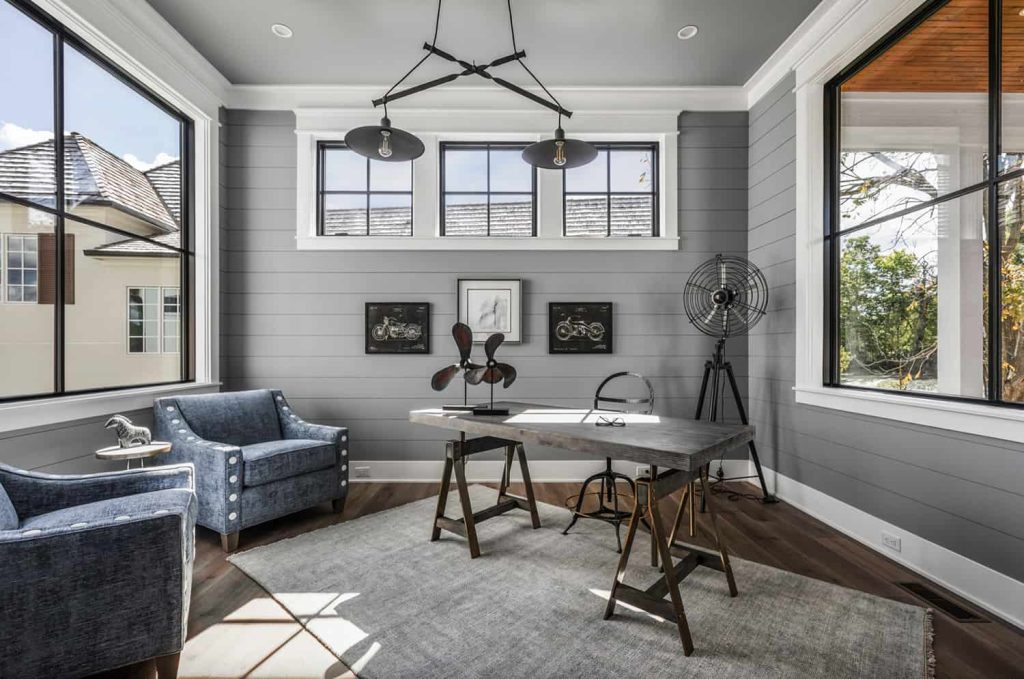 Industrial farmhouse home office with gray shiplap walls and adjustable sawhorse wood desk