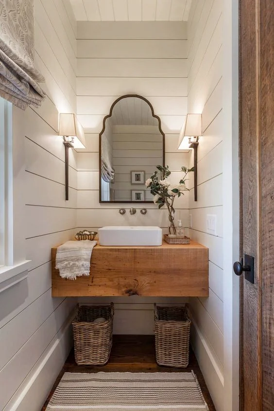 shiplap bathroom in a small space with vintage mirror and baskets