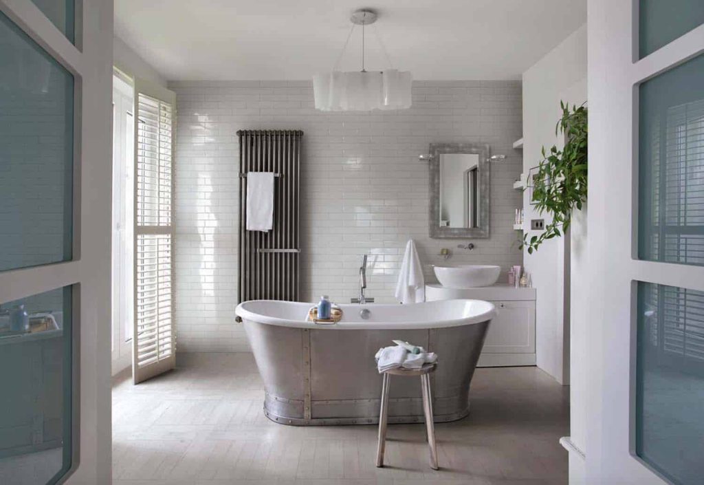 stunning farmhouse bathroom features a freestanding tub and white subway tiles 
