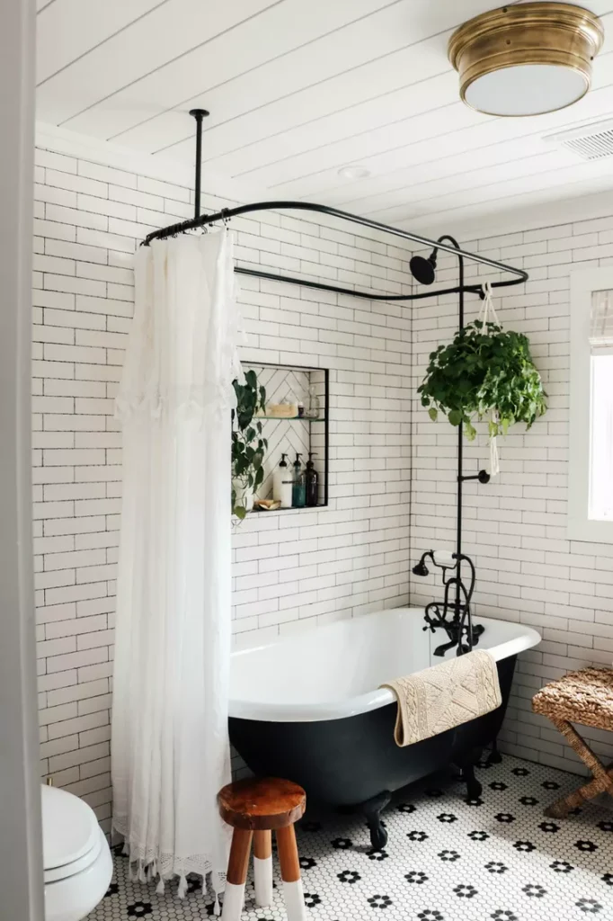French farmhouse bathroom with a subway tiled backsplash, an elegant clawfoot tub, and a paneled ceiling.