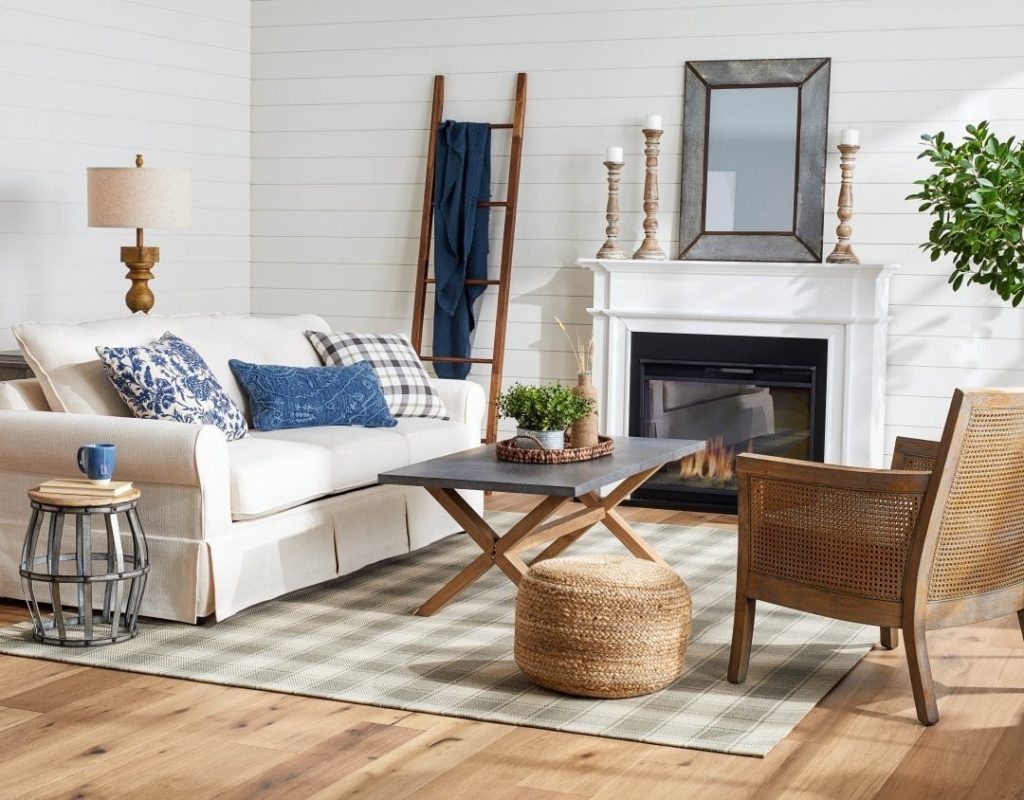 Farmhouse living room with shiplap walls a blanket ladder and white fireplace