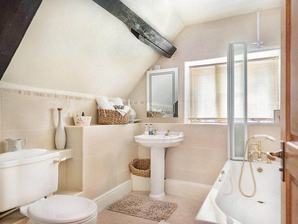 Modern influences coupled with farmhouse style in the small attic level bathroom