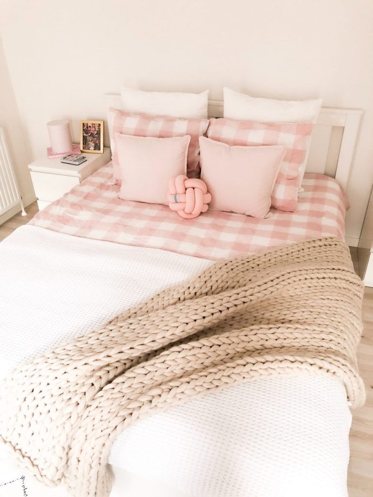 Simple farmhouse style for girls bedroom with chunky knit throw and pink buffalo check bedding